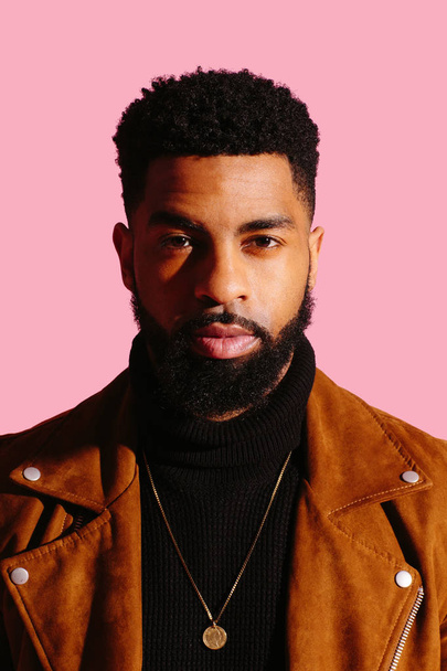 Retrato de un hombre guapo con barba de un aislado sobre fondo rosa estudio - Foto, imagen