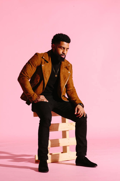 stylischer, gutaussehender und cooler afrikanisch-amerikanischer Mann mit Bart, isoliert auf rosa Studiohintergrund - Foto, Bild