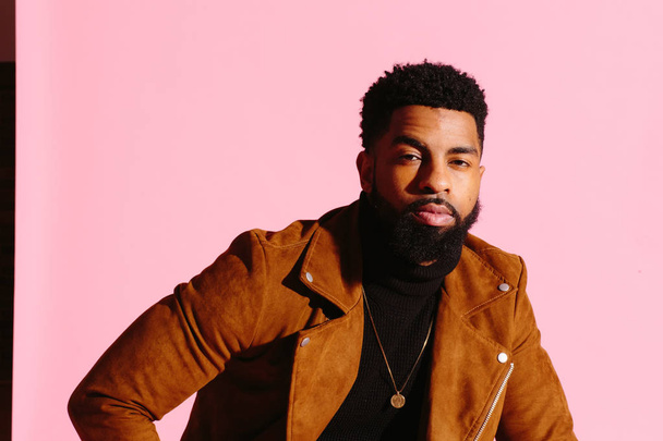 Stylish, handsome and cool African American man with beard, isolated on pink studio background - Photo, Image