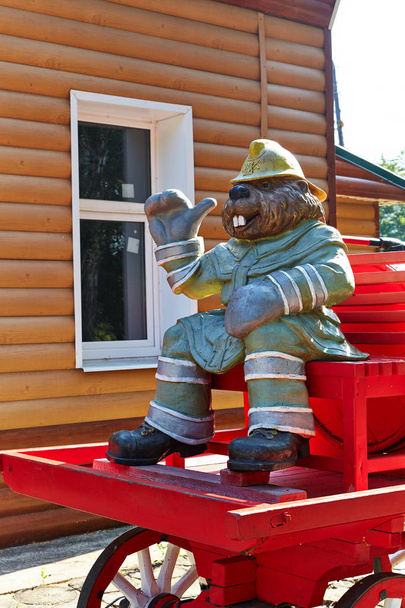 Una figura del castor de un bombero en un carro con un barril y una bomba. Entrada al museo de los incendios. Reserva Natural de Voronezh, Rusia
. - Foto, Imagen