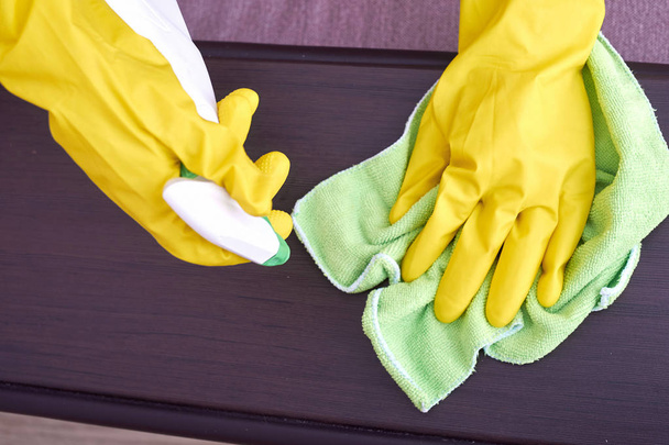 木製の表面を洗浄する黄色の手袋での手の画像 - 写真・画像