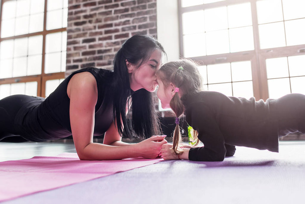 Mother and daughter working out together doing plank exercise - Foto, Imagem