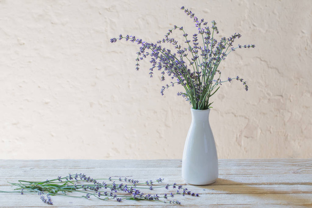 lavender in white vase on wooden table - Fotoğraf, Görsel