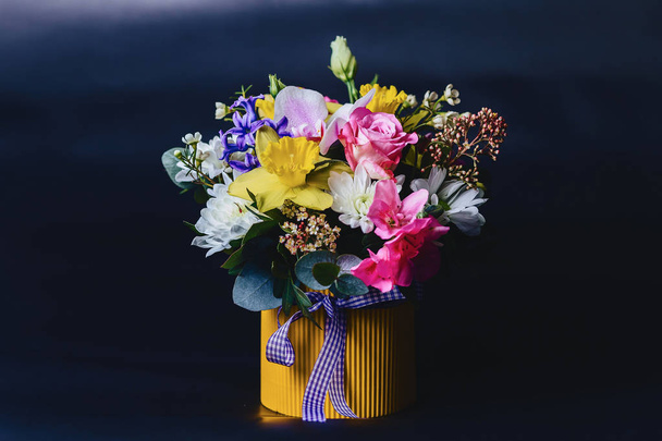 ramo de flores de color en la cesta sobre fondo oscuro
 - Foto, Imagen