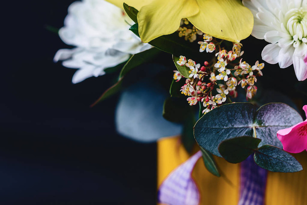 farbige Blumensträuße im Korb auf dunklem Hintergrund - Foto, Bild