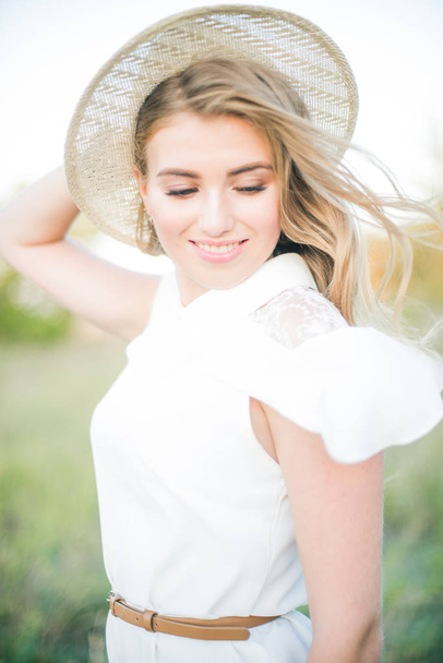Menina bonita com cabelo longo loiro no verão em um campo em um dia ensolarado
 - Foto, Imagem