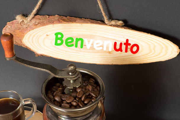 Um moedor de café, grãos de café e um sinal com o slogan Welcome
 - Foto, Imagem