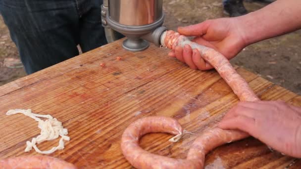 El carnicero está rellenando el intestino de cerdo con carne picada para hacer salchichas. Llenar los intestinos de cerdo para hacer salchichas con máquina para salchichas hechas a mano
. - Metraje, vídeo