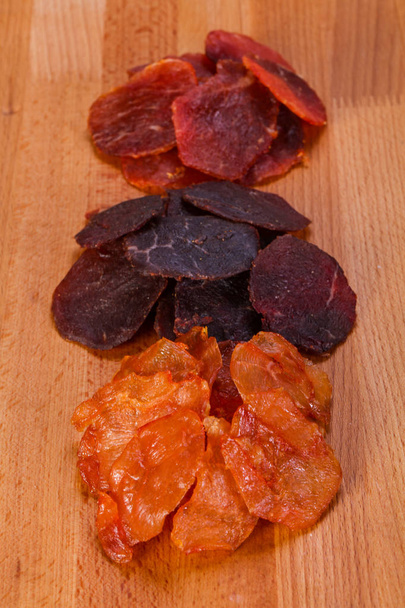 Закуски из сухого мяса на деревянном фоне
 - Фото, изображение