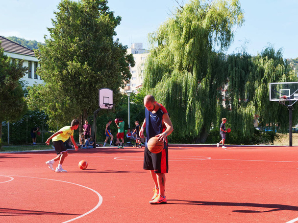Kluż-Napoka, Rumunia-11 sierpień 2018: Szczęśliwy nastolatków i dorosłych gry w koszykówkę na plac zabaw w słoneczny letni dzień - Zdjęcie, obraz