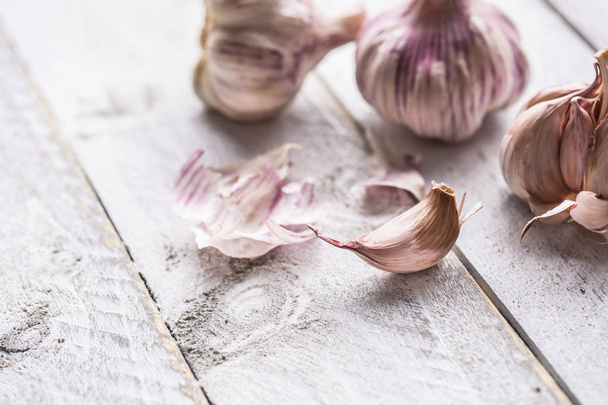 Garlic cloves and bulbs on vintage wooden table. - Photo, Image