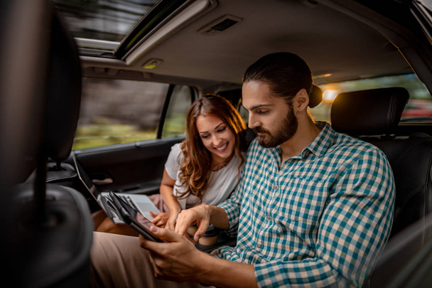Young confident business partners working on business trip on back seat in car   - Foto, Imagen