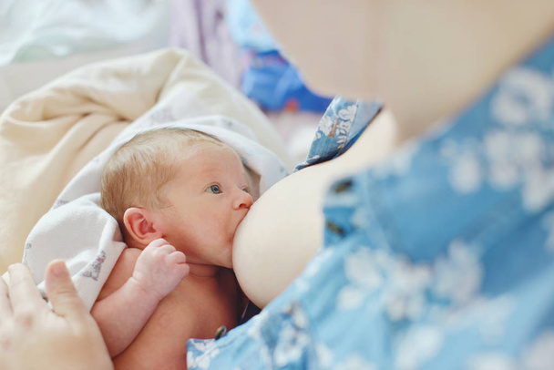 彼女の腕を自宅で母親の母乳赤ちゃん - 写真・画像