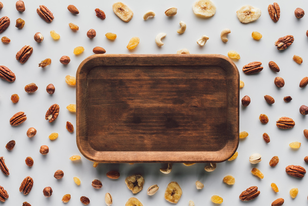 tasainen lay kuivattuja hedelmiä ja pähkinöitä puinen levy keskellä eristetty valkoisella pohjalla
 - Valokuva, kuva