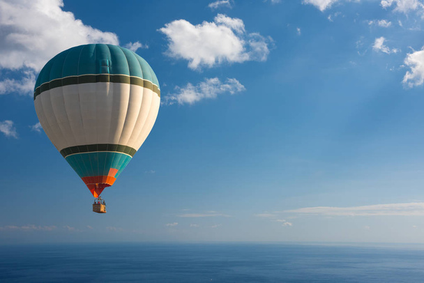Colorful hot air balloon fly over the blue sea - Valokuva, kuva