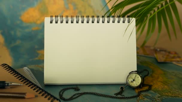 Time to travel concept. Tropical vacation theme with world map and notebook. Trip items with copy space - Footage, Video