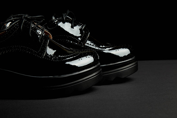 Woman female black oxford platform shoes on black background. Brogue shoes. Copy space.   - Photo, Image