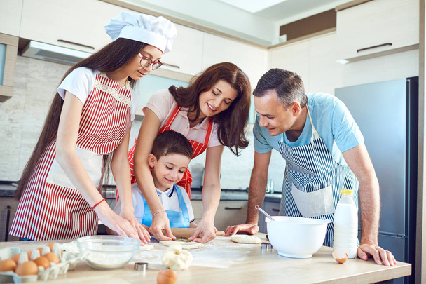 A happy family prepares baking in the kitchen - Фото, изображение