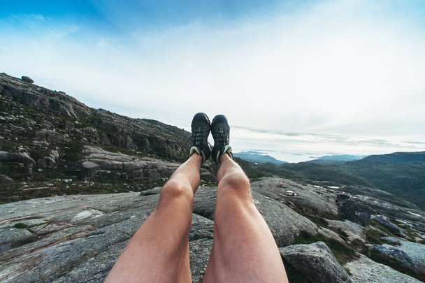 The tourist put his feet above the rock - Valokuva, kuva