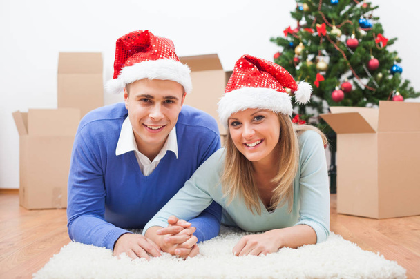 Happy couple is celebrating Christmas in their new home. - Фото, изображение