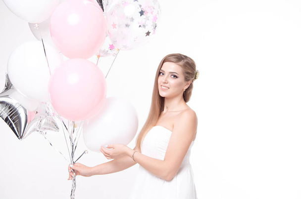 gorgeous woman in white dress holding bundle of balloons - Foto, imagen