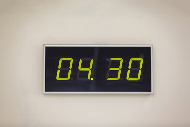 Zwarte digitale klok op een witte achtergrond met tijd 4 uur en 30 minuten - Foto, afbeelding