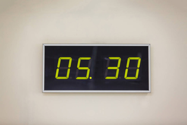 Relógio digital preto sobre um fundo branco mostrando o tempo 5 horas 30 minutos
 - Foto, Imagem