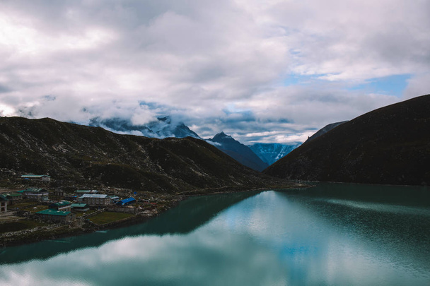 Himalayas mountains. Lake in the mountains, rocks in clouds. View on the lake Gokyo Ri not far from Everest. Colorful landscape with beautiful rocks and dramatic cloudy sky. Nature background. - Φωτογραφία, εικόνα