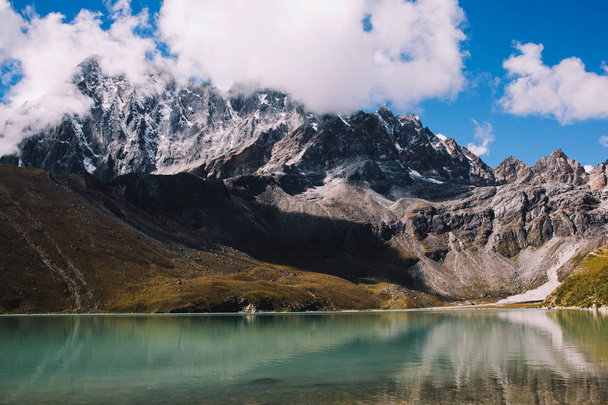 Mountain range with beautiful clouds. Mountain landscape. View on the lake Gokyo Ri. Blue sky with clouds. Himalaya mountains of Nepal, snow covered high peaks and lake not far from Everest. - 写真・画像