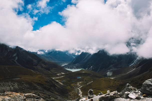 Himalayas mountains. Lake in the mountains, rocks in clouds. View on the lake Gokyo Ri not far from Everest. Colorful landscape with beautiful rocks and dramatic cloudy sky. Nature background. - 写真・画像