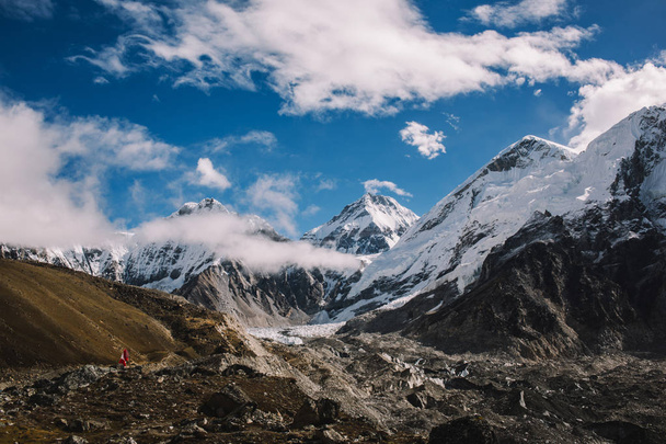 High mountains with snowy peaks in clouds at bright sunny day in Nepal. Colorful landscape with beautiful rocks and dramatic cloudy sky. Nature background. Amazing mountains. Way to Everest base camp. - Фото, зображення