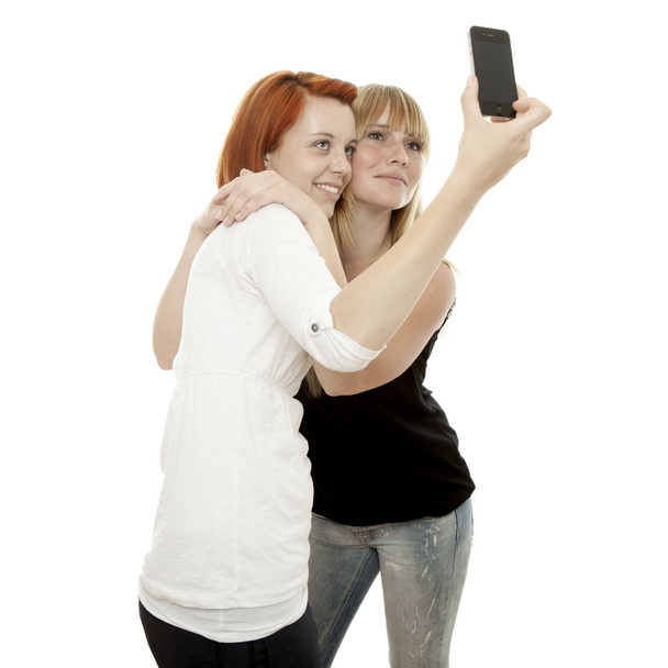 genç güzel sarışın ve Kızıl saçlı kız portresi ile telefon - Fotoğraf, Görsel