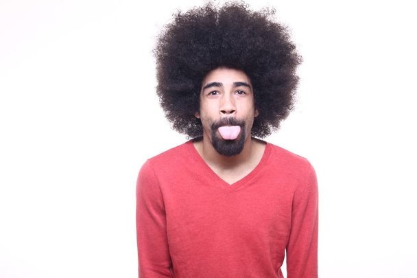 Black man with curly hair showing tongue - Foto, Imagen
