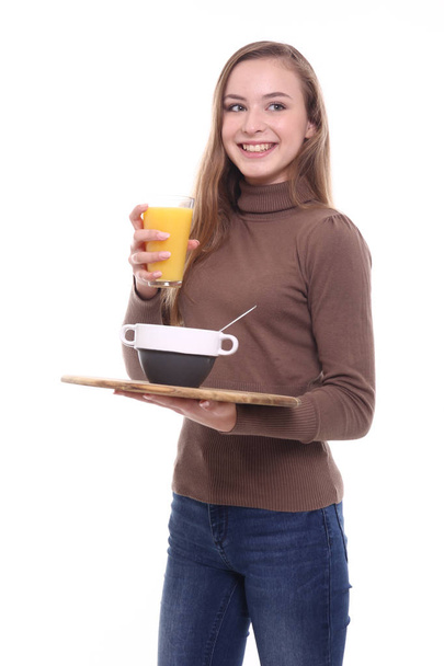 Beautiful caucasian girl is holding tray with bowl and juice - 写真・画像