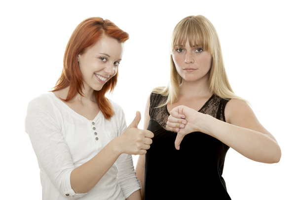 young beautiful red and blond haired girls thumb up and down - Фото, изображение