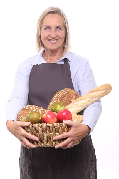 Woman holding basket with different bread and fruits - Φωτογραφία, εικόνα