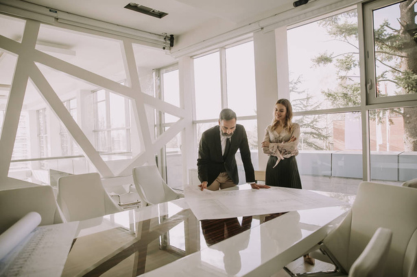 Podnikatelé při pohledu na plány v moderní kanceláři - Fotografie, Obrázek