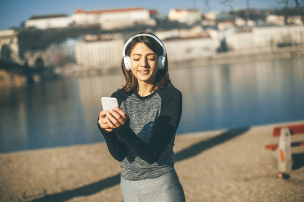 Молодая спортсменка с мобильным телефоном на мосту в Будапеште, Венгрия
 - Фото, изображение