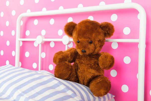 Girls bedroom with pink wall paper and stuffed bear - Photo, image