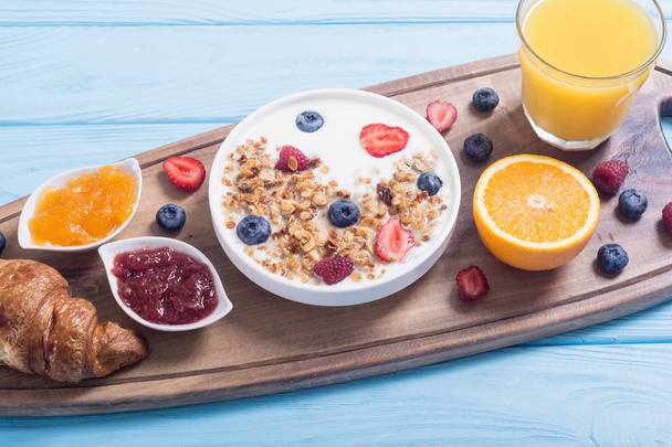 Breakfast with yogurt, granola, berries, orange juice, croissant and jam - Fotografie, Obrázek