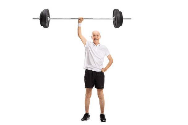 Full length portrait of a senior lifting a barbell with one hand isolated on white background - Φωτογραφία, εικόνα
