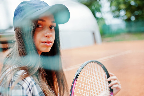 Young sporty girl player with tennis racket on tennis court. - Photo, image