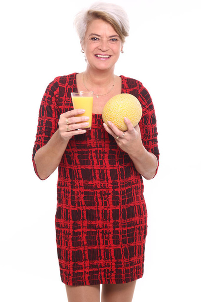 Blonde woman holding glass with juice and melon - Φωτογραφία, εικόνα