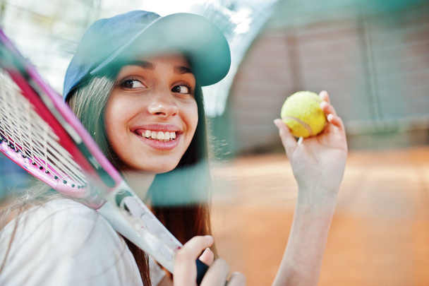 Young sporty girl player with tennis racket on tennis court. - Valokuva, kuva