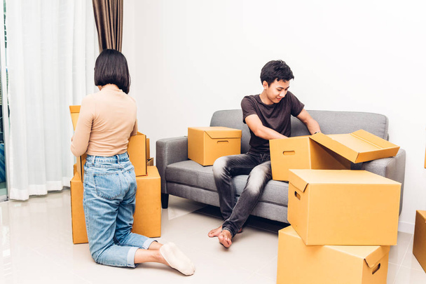 Happy young couple unpacking box and moving into their new home.House moving and real estate concept - Photo, Image
