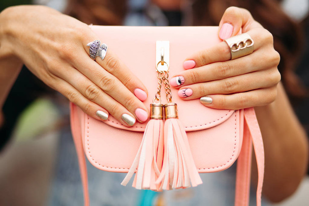 Hermosas manos de mujer con manicura de moda sosteniendo precioso bolso de melocotón
. - Foto, Imagen