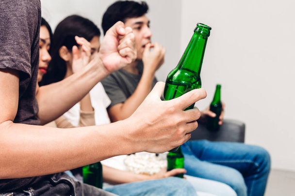 Skupina přátel jíst popcorn a společně popíjeli pivo a sledovat fotbal na gauči doma. Přátelství a stranou koncept - Fotografie, Obrázek