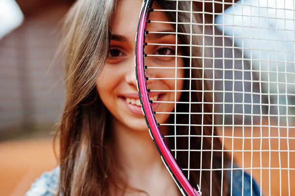 Young sporty girl player with tennis racket on tennis court. - 写真・画像