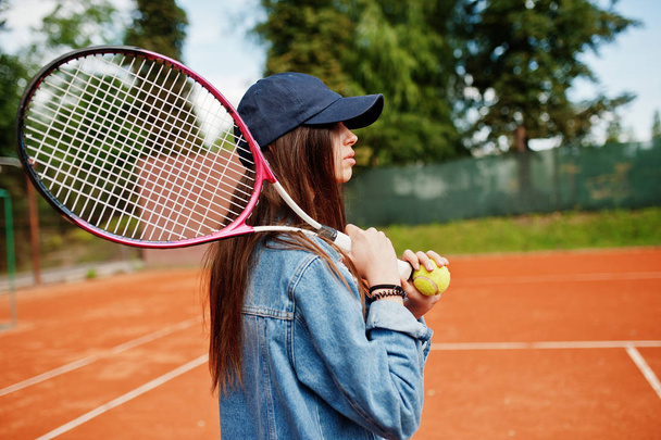 Young sporty girl player with tennis racket on tennis court. - Фото, изображение