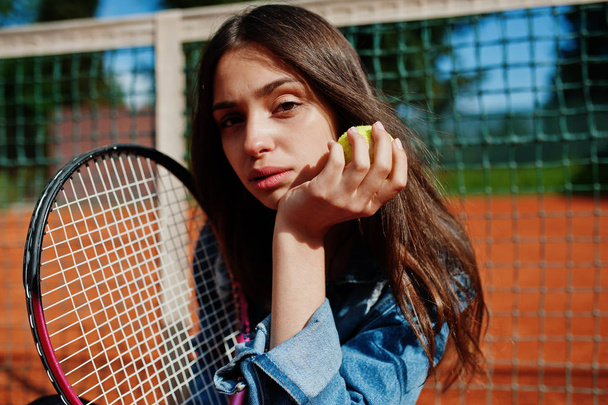 テニスコートでテニス ラケットを持つスポーティーな少女プレイヤー. - 写真・画像